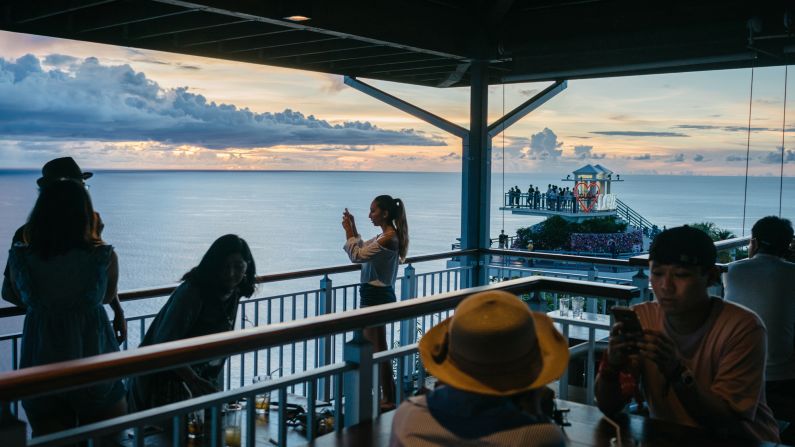 A tourist takes a picture of a sunset at Terraza Cafe and Grill, a restaurant in northern Guam, on Monday, August 14. Many people were vacationing on the island, a US territory in the Pacific, just days after<a href="http://www.cnn.com/2017/08/08/politics/north-korea-considering-guam-strike-trump/index.html" target="_blank"> it was threatened</a> by North Korean leader Kim Jong Un.