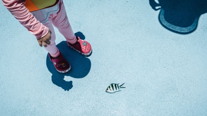 A child looks at a fish that had just been caught on Monday, August 14.