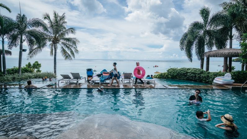 Tourists enjoy a swimming pool at the Dusit Thani Guam Resort.