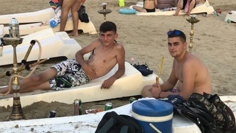 Beachgoers smoking hookah in the seaside town largely untouched by the war.