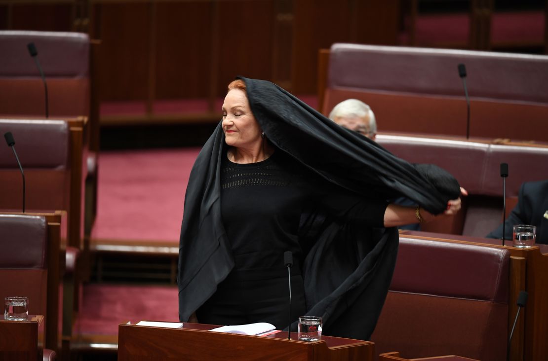 Hanson takes off her burqa veil during Senate Question Time at Parliament House in Canberra.