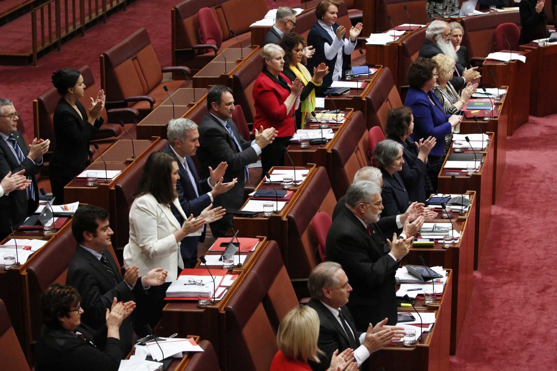 Members of the Senate stand and applaud Attorney-General George Brandis after the exchange.