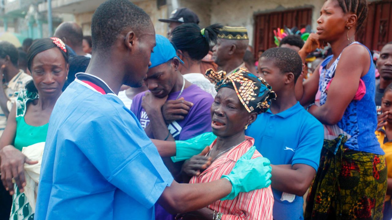A relative of a mudslide victim receives comfort Wednesday at the Freetown morgue.