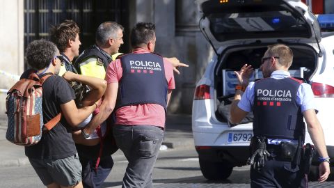 An injured person is carried in Barcelona on Thursday.