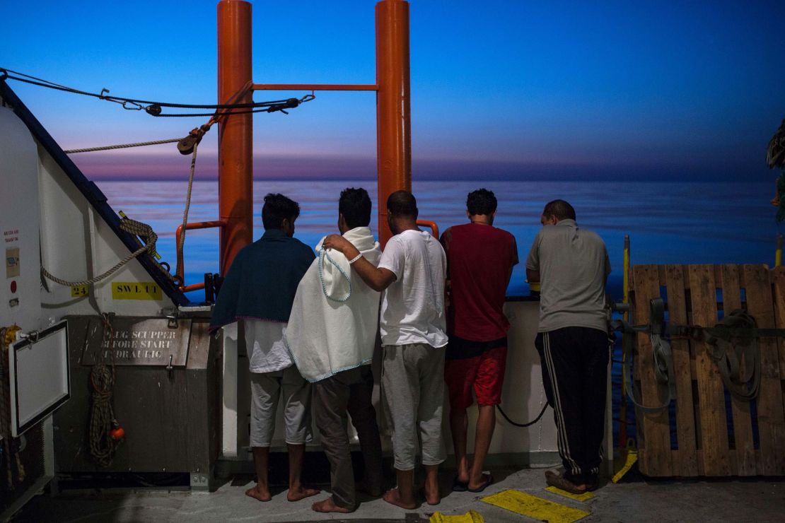 Migrants watch sunrise from the Aquarius rescue ship after their transfer from the NGO Migrant Offshore Aid Station (MOAS) in August 2017.