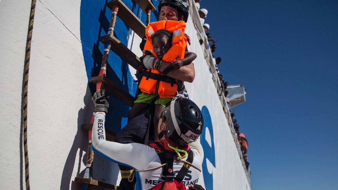 A member of Aquarius, a rescue ship run by NGO SOS Méditerranée and Doctors Without Borders, brings a young girl on board in August 2017.