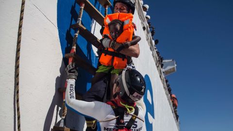 A member of Aquarius, a rescue ship run by NGO SOS Méditerranée and Doctors Without Borders, brings a young girl on board in August 2017.