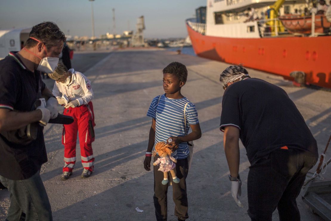 A child, who was aboard the Aquarius rescue ship, receives flip-flops upon her arrival in the port of Pozzallo, Italy, in August 2017.  