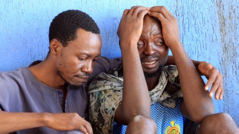 Migrants react after being returned to a detention center in Libya. 