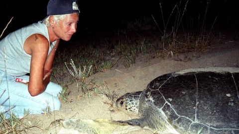 Mona Khalil, a Lebanese ecologist, activist looks at a turtle at a coast in the southern Lebanese port city of Tyre in 2002.