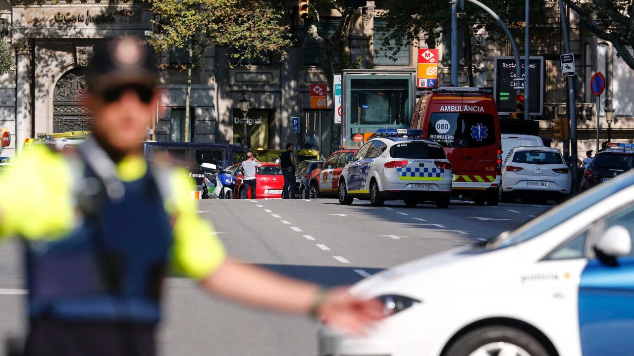 A policemen stand as he blocks the street to a cordoned off area after a van ploughed into the crowd, injuring several persons on the Rambla in Barcelona on August 17, 2017. / AFP PHOTO / PAU BARRENA        (Photo credit should read PAU BARRENA/AFP/Getty Images)