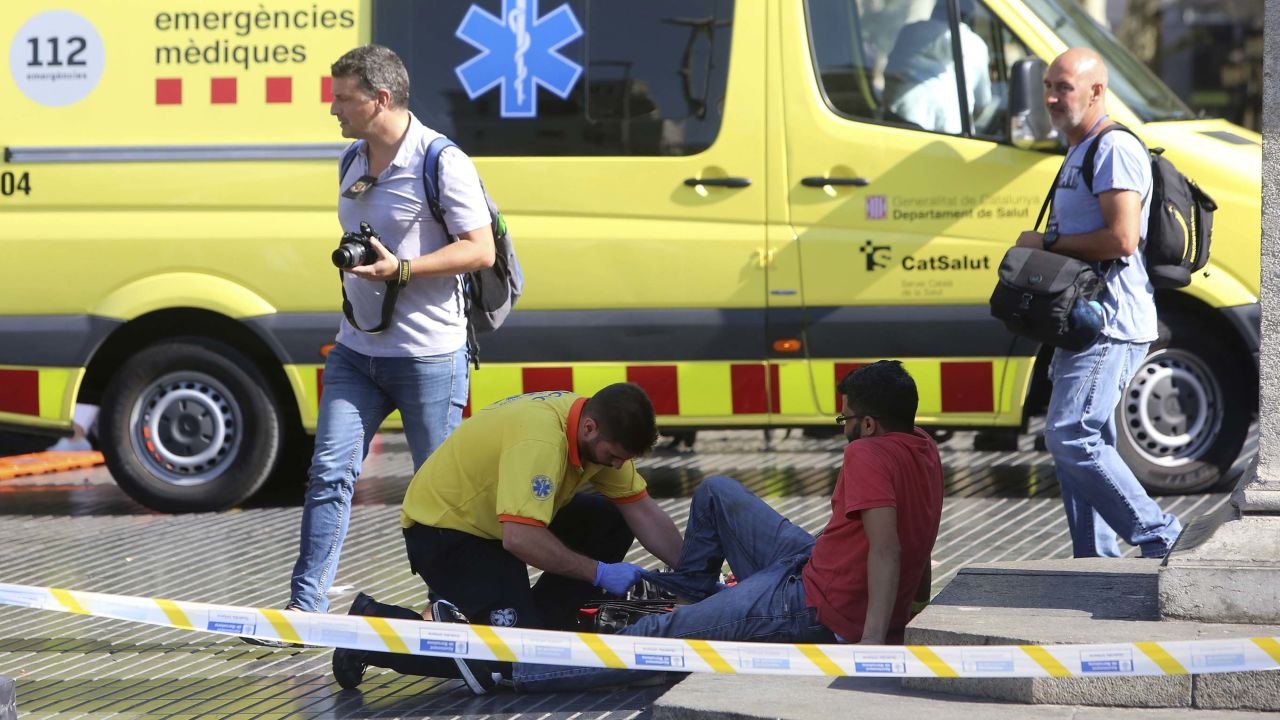 An injured person is treated Thursday after a van jumped the sidewalk in Barcelona's Las Ramblas area.