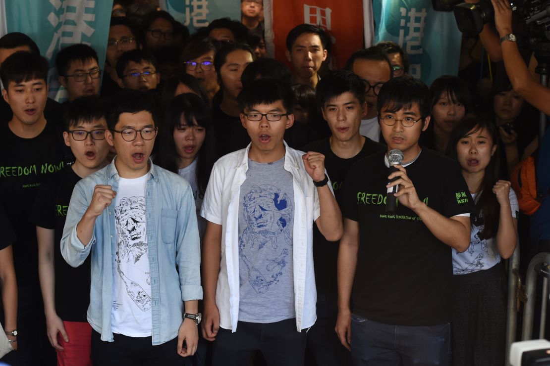 Nathan Law (L), Joshua Wong (C) and Alex Chow, leaders of Hong Kong's 'Umbrella Movement', gesture as they address the media before their sentencing in Hong Kong on August 17, 2017.