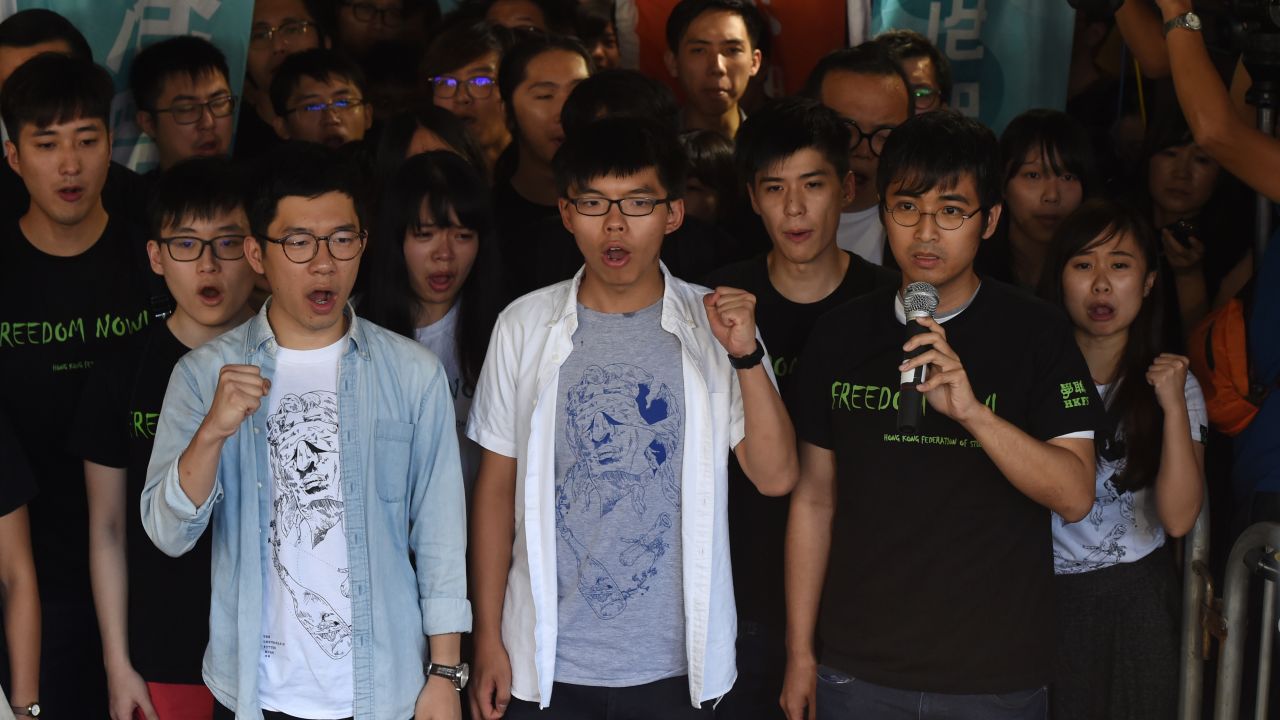 Nathan Law (L), Joshua Wong (C) and Alex Chow, leaders of Hong Kong's 'Umbrella Movement', gesture as they address the media before their sentencing in Hong Kong on August 17, 2017.