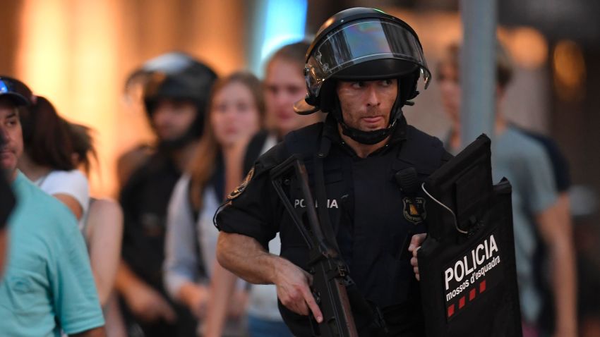 Spanish policemen stand guard in a cordoned off area after a van ploughed into the crowd, killing 13 persons and injuring over 50 on the Rambla in Barcelona on August 17, 2017.
A driver deliberately rammed a van into a crowd on Barcelona's most popular street on August 17, 2017 killing at least 13 people before fleeing to a nearby bar, police said. 
Officers in Spain's second-largest city said the ramming on Las Ramblas was a "terrorist attack" and a police source said one suspect had left the scene and was "holed up in a bar". The police source said they were hunting for a total of two suspects. / AFP PHOTO / LLUIS GENE        (Photo credit should read LLUIS GENE/AFP/Getty Images)