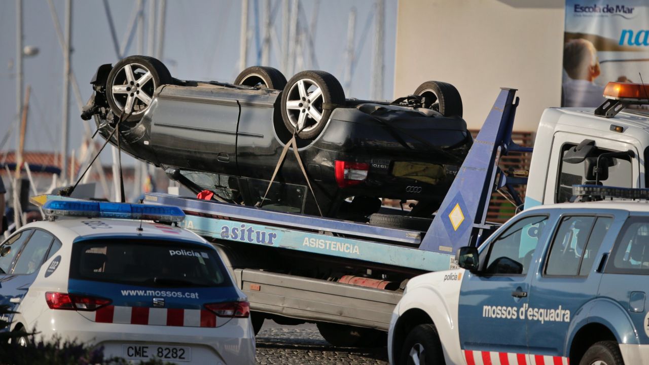An overturned car is transported on a platform from the spot where terrorists were intercepted by police in Cambrils, Spain, Friday, Aug. 18, 2017. The police force for Spain's Catalonia region says the five suspects shot and killed in the resort town of Cambrils were carrying bomb belts, which have been detonated by the force's bomb squad. (AP Photo/Emilio Morenatti)