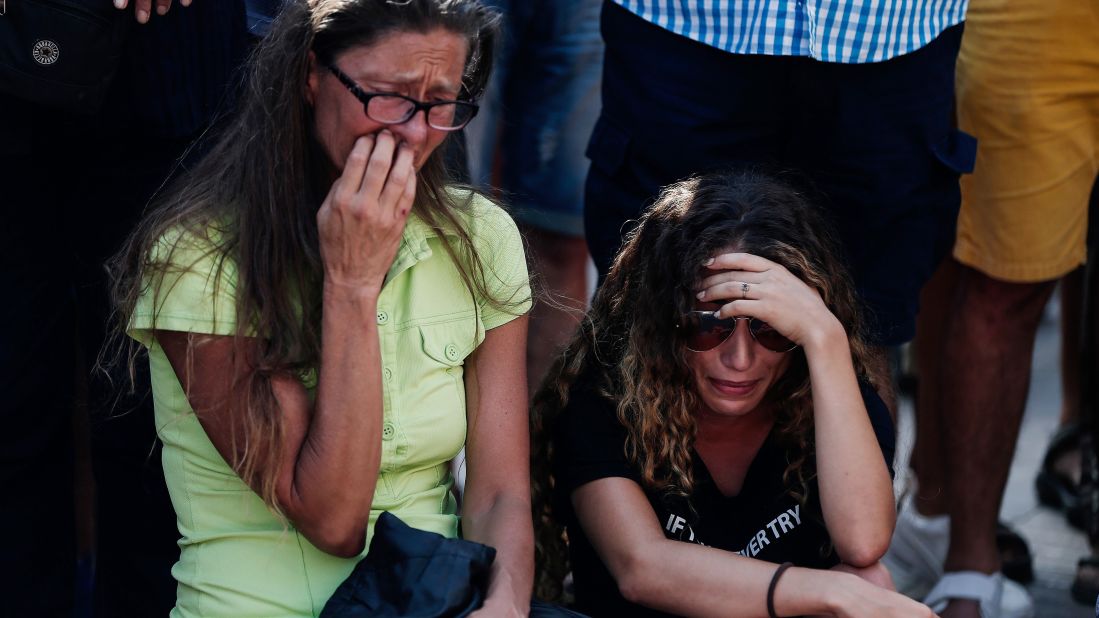 Two women cry at the street memorial in Barcelona on Friday, August 18.