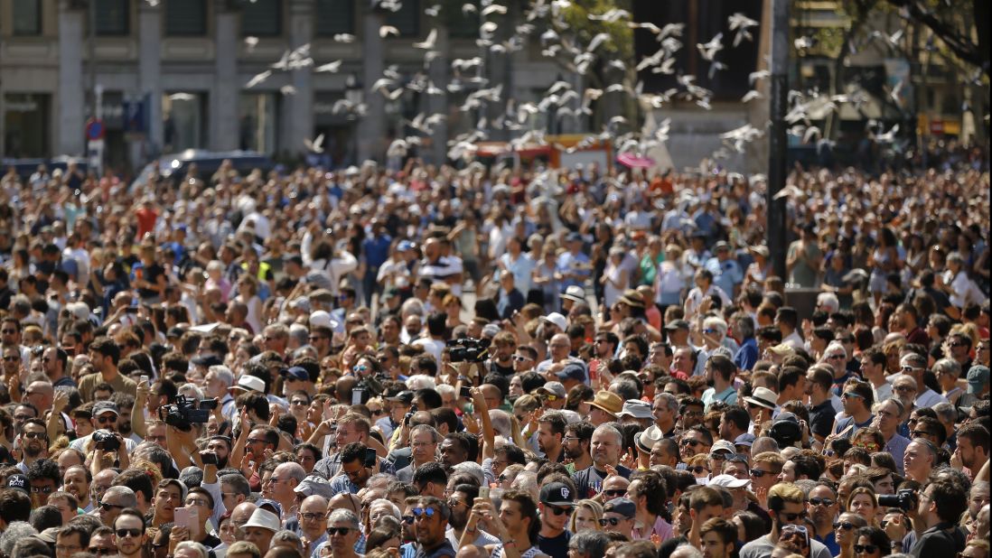 Pigeons fly over a Barcelona crowd that gathered for a minute of silence on August 18.