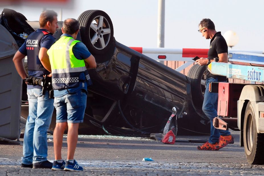 Police officers investigate a car in Cambrils.