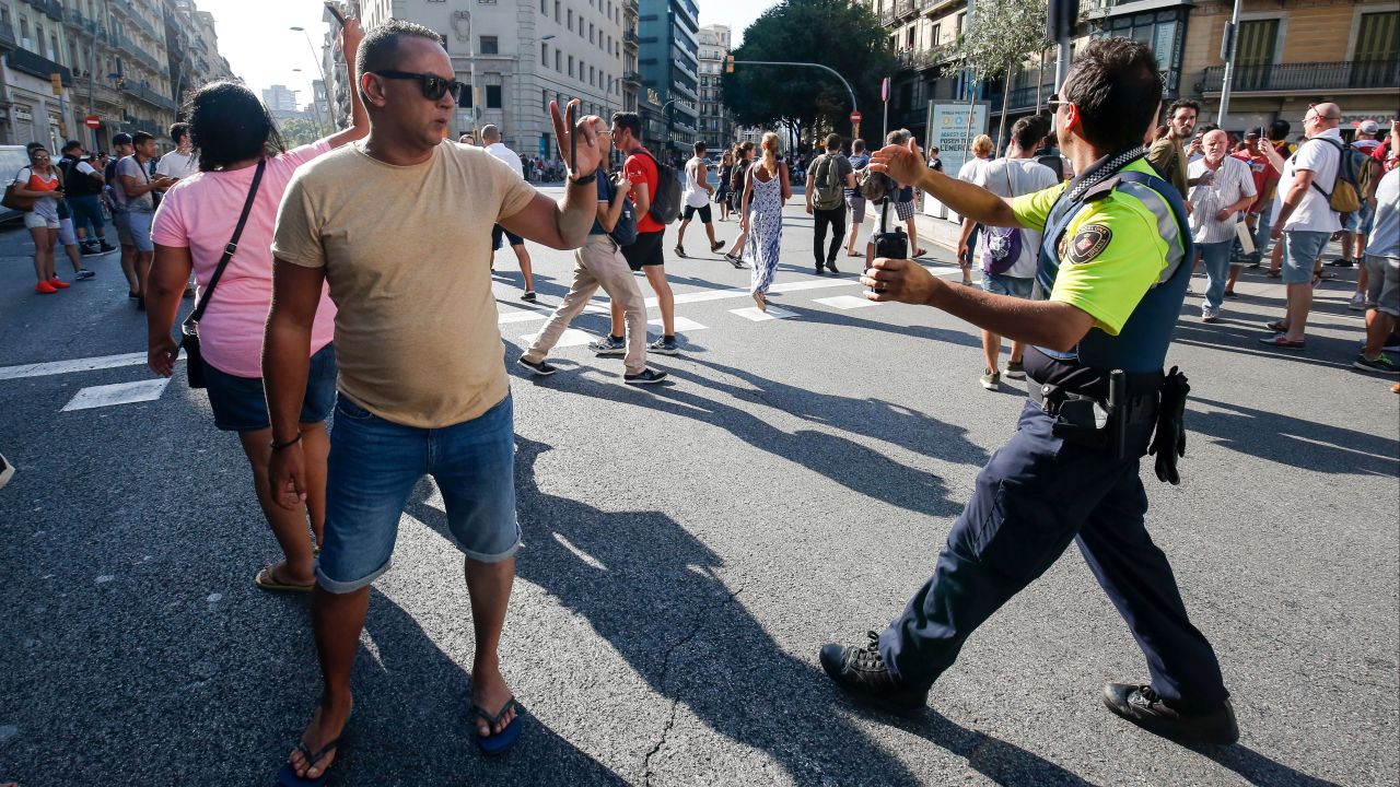 A police officer asks people to move back in Barcelona.