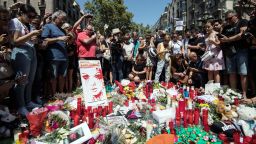 People gather around tributes laid on Las Ramblas near the scene of yesterday's terrorist attack, on August 18, 2017 in Barcelona, Spain. Fourteen people were killed and dozens injured when a van hit crowds in the Las Ramblas area of Barcelona on Thursday. Spanish police have also killed five suspected terrorists in the town of Cambrils to stop a second terrorist attack. 