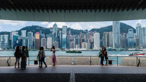 A Star Ferry is seen passing tourists gathered at the Kowloon public pier overlooking Hong Kong's Victoria Harbour.