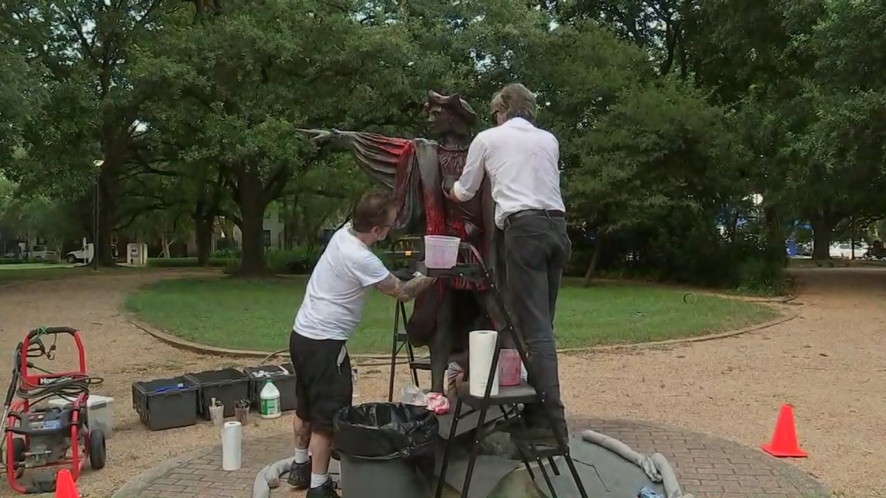 Men cleaning the statue after it was vandalized. 