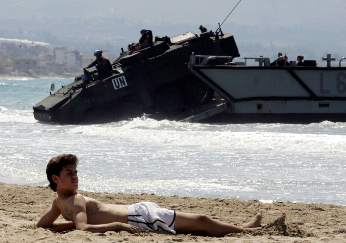 In 2006, militant group Hezbollah fought a war with neighboring Israel, resulting in the deployment of UN forces. Here, a boy lies on the beach in Tyre as Spanish UN troops arrive in the city.