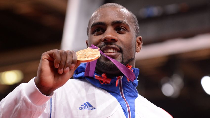France's Teddy Riner poses with his gold medal on the podium after he won the men's +100kgs final contest match of the judo event at the London 2012 Olympic Games on July 28, 2012 in London. AFP PHOTO / TOSHIFUMI KITAMURA (Photo credit should read TOSHIFUMI KITAMURA/AFP/GettyImages)