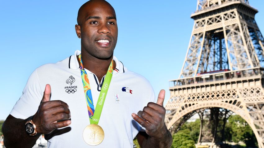 French judoka Teddy Riner poses with his gold medal in front of the Eiffel tower on August 23, 2016 in Paris. 
France's Olympic team landed in Paris on August 23, 2016 after winning 42 medals in Rio, including 10 golds, a postwar record for the overall medal count. / AFP / Bertrand GUAY        (Photo credit should read BERTRAND GUAY/AFP/Getty Images)