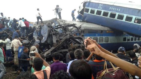 Police and volunteers look for survivors Saturday in the wreckage of a train derailment in northern India.