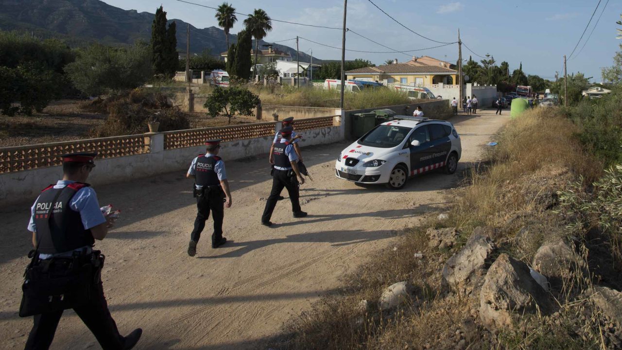 Armed police walk down a dirt road toward the scene of the explosion in Alcanar.