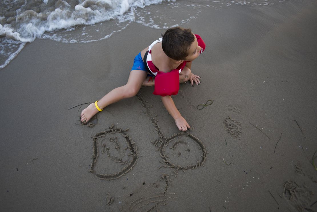 Romera and Gonzalez' 4-year-old son sketches in the sand on Playa Cementera.