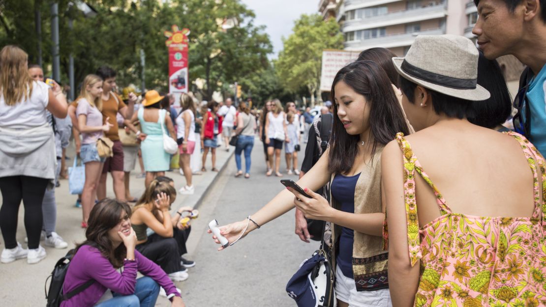 Tourists take a group selfie outside the Sagrada Familia.