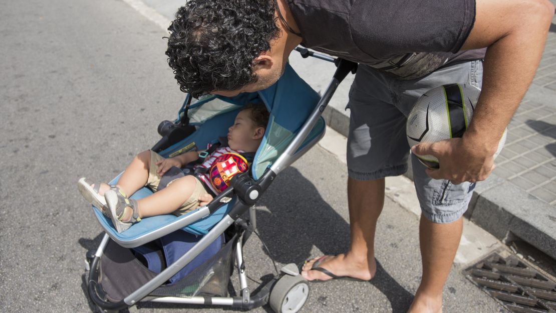 Henrique Sposito checks on his son Davi in a stroller outside the Sagrada Familia.