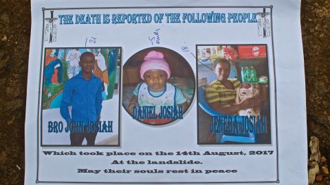 Gabriel Fattah Manga holds a poster showing the family members he lost in the mudslide that hit Sierra Leone's capital, Freetown.