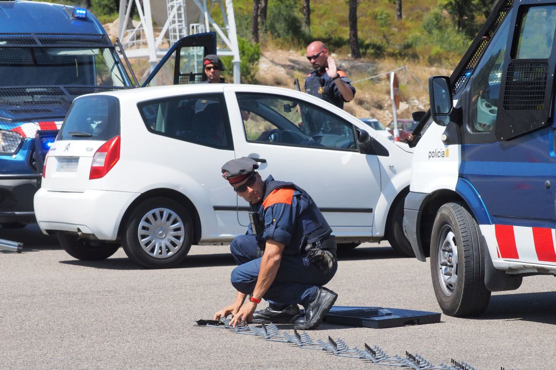 A Spanish police officer deploys a "spike strip" at the border between La-Jonquera in northern Spain and Le-Perthus in southern France.