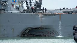 Damage to the portside is visible as the Guided-missile destroyer USS John S. McCain (DDG 56) steers towards Changi naval base in Singapore following a collision with the merchant vessel Alnic MC Monday, Aug. 21, 2017. The USS John S. McCain was docked at Singapore's naval base with "significant damage" to its hull after an early morning collision with the Alnic MC as vessels from several nations searched Monday for missing U.S. sailors.