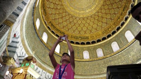 A Palestinian boy from Gaza takes a photo inside the Dome of the Rock mosque.