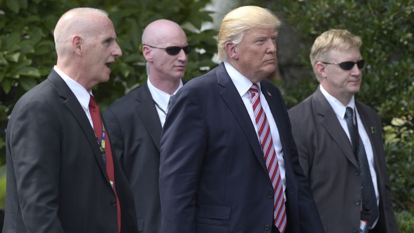 President Donald Trump, his longtime bodyguard Keith Schiller, left, and two Secret Service agents walk along the South Lawn of the White House in Washington, Monday, June 12, 2017, following a ceremony where the president honored the 2016 NCAA Football National Champions Clemson University Tigers.