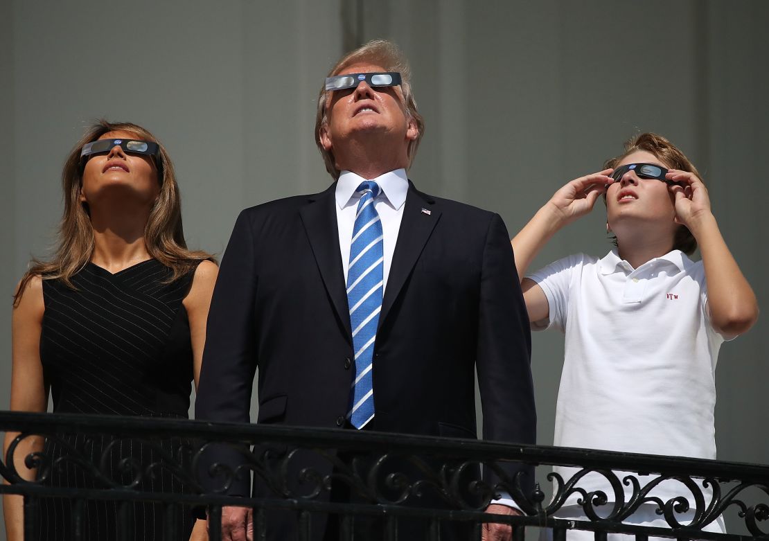 President Donald Trump, first lady Melania Trump and their son Barron Trump wear special glasses to view the solar eclipse from the Truman Balcony at the White House on August 21, 2017 in Washington, DC. 