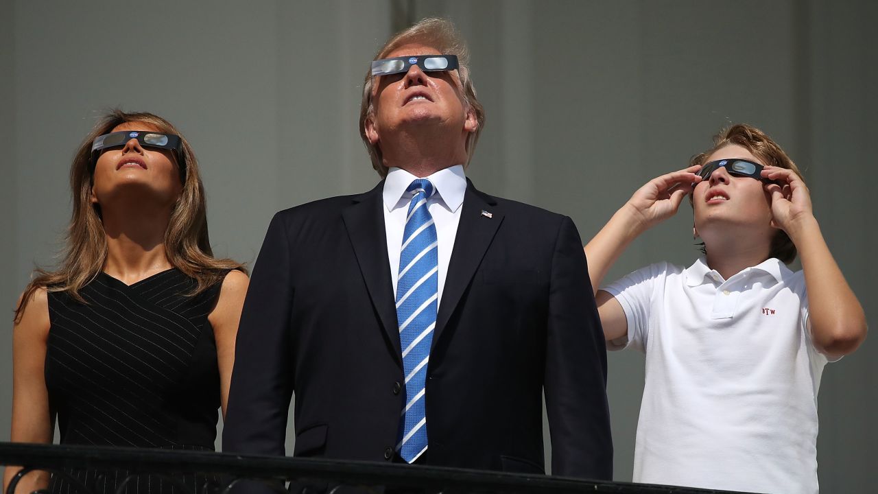 President Donald Trump, first lady Melania Trump and their son Barron Trump wear special glasses to view the solar eclipse from the Truman Balcony at the White House on August 21, 2017 in Washington, DC. 