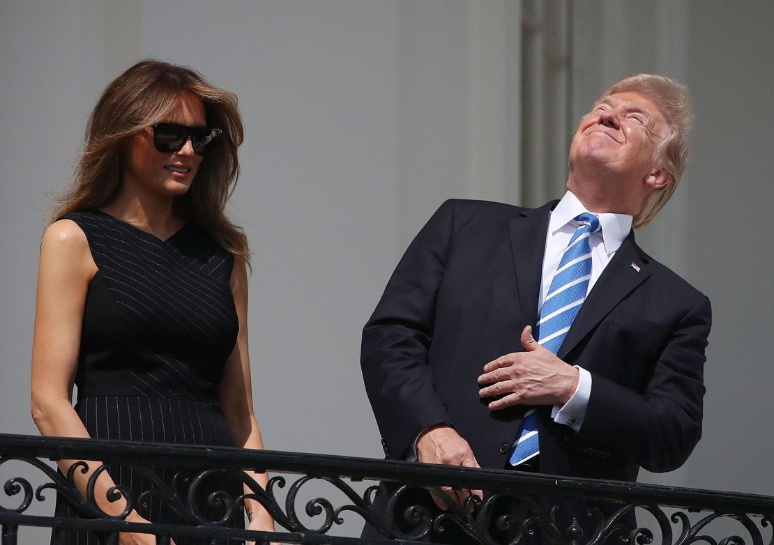 President Donald Trump looks up toward the Solar Eclipse while joined by his wife first lady Melania Trump on the Truman Balcony at the White House on August 21, 2017.
