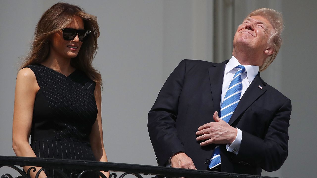 President Donald Trump looks up toward the Solar Eclipse while joined by his wife first lady Melania Trump on the Truman Balcony at the White House on August 21, 2017.