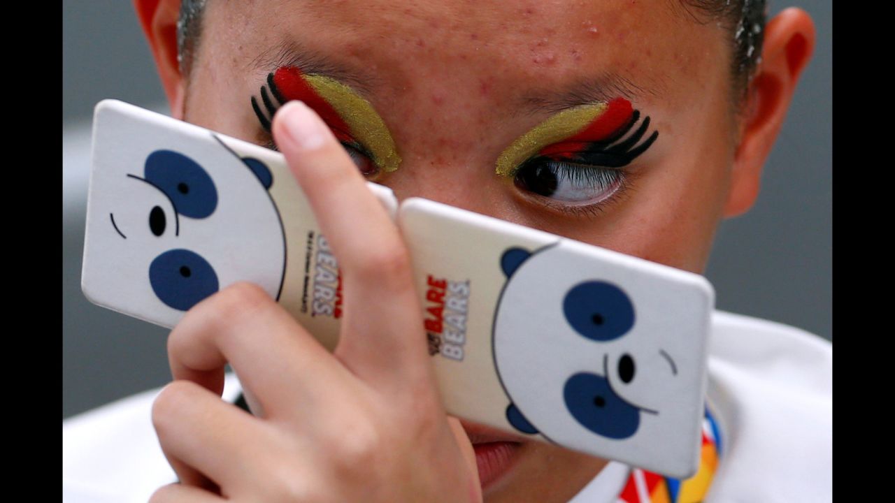 A synchronized swimmer from Thailand checks her makeup before competing in the Southeast Asian Games on Sunday, August 20.