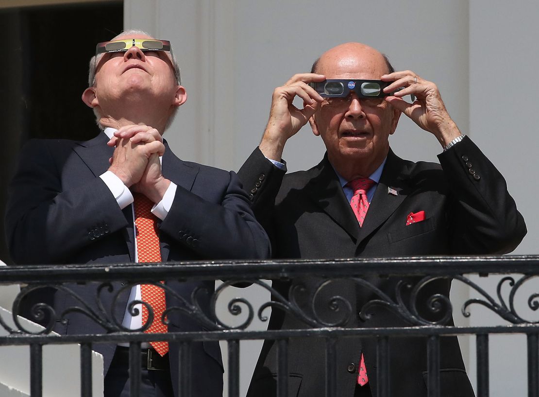 Attorney General Jeff Sessions (left) and Commerce Secretary Wilbur Ross wear special glasses to view the solar eclipse at the White House on August 21, 2017.