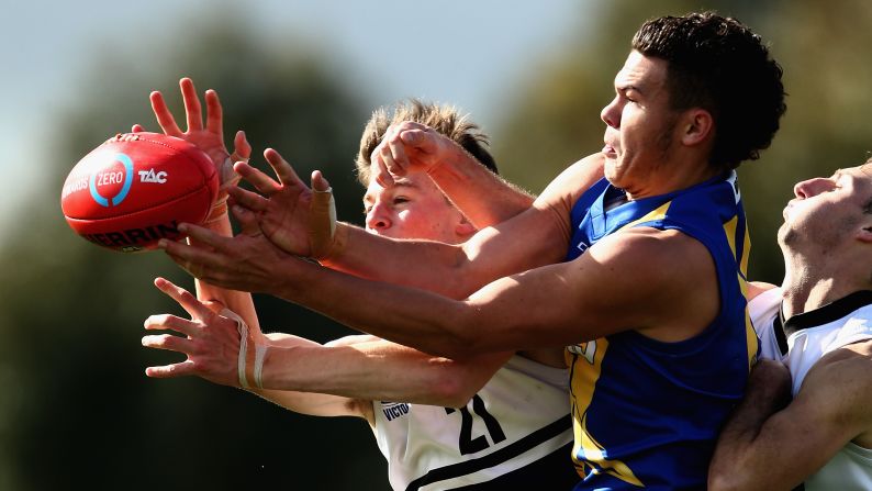 Players reach for the ball during an Australian rules football match in Melbourne on Saturday, August 19.