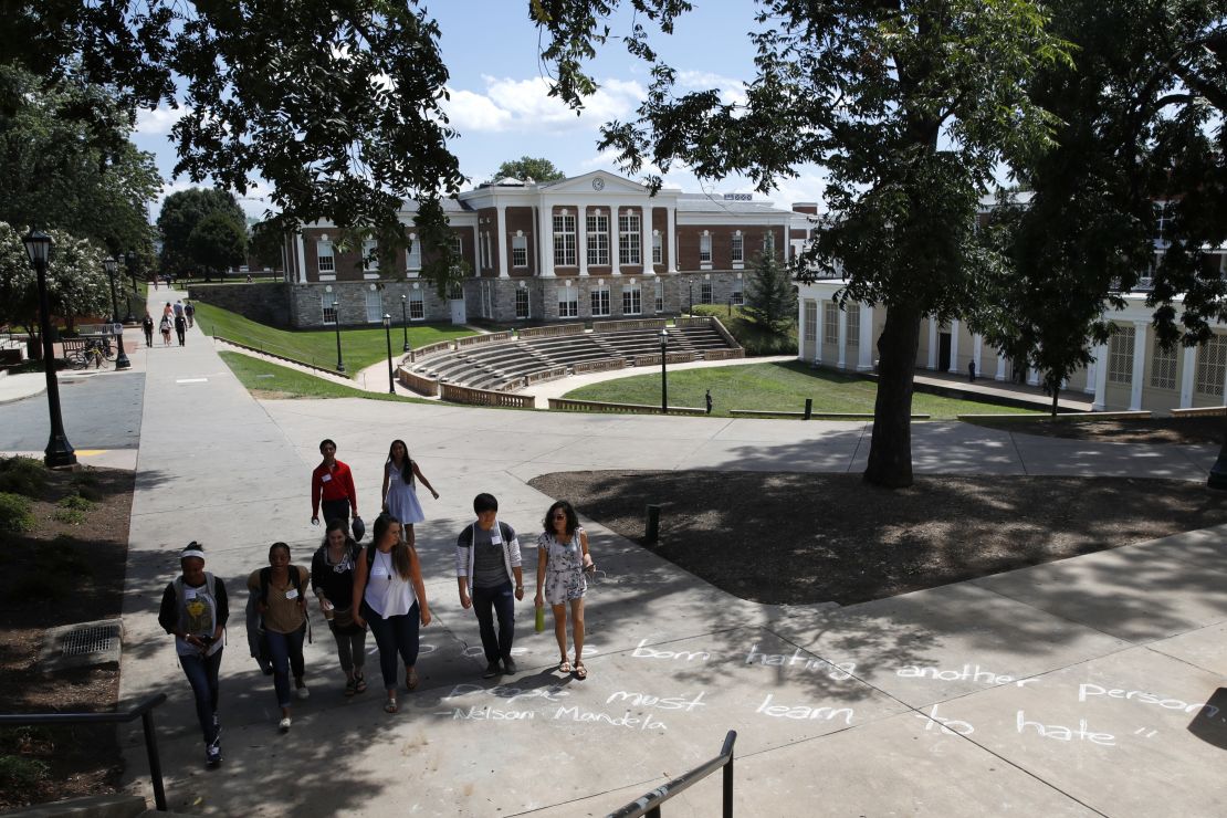 Students walk past a quote in chalk credited to Nelson Mandela at the University of Virginia on August 18. The quote says, "No one is born hating another person. People must learn to hate." 