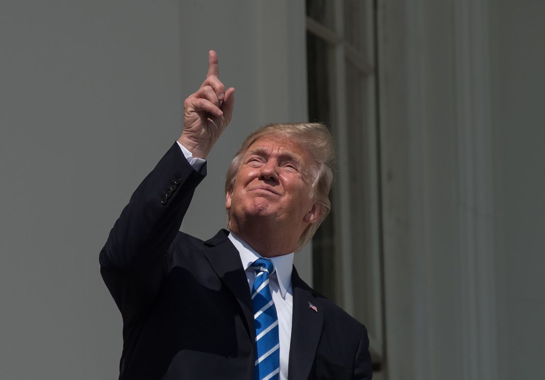 President Donald Trump looks up at the partial solar eclipse from the balcony of the White House in Washington, DC, on August 21, 2017.