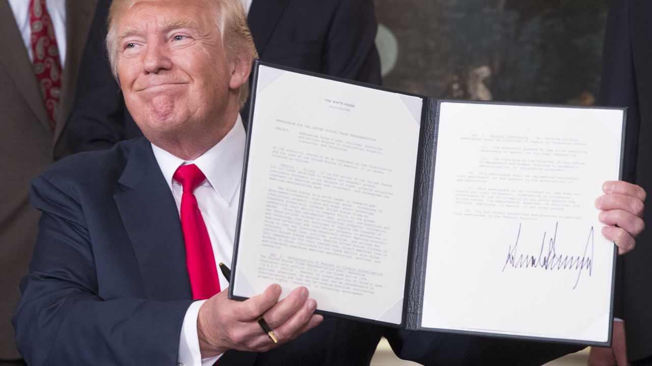 WASHINGTON, D.C. - AUGUST 14: (AFP-OUT) U.S. President Donald J. Trump holds a memorandum he just signed on addressing China's laws, policies, practices, and actions related to intellectual property, innovation, and technology at The White House on August 14, 2017 in Washington, DC. (Photo by Chris Kleponis-Pool/Getty Images)